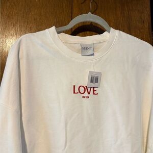White Seint sweatshirt with red embroidered “Love”